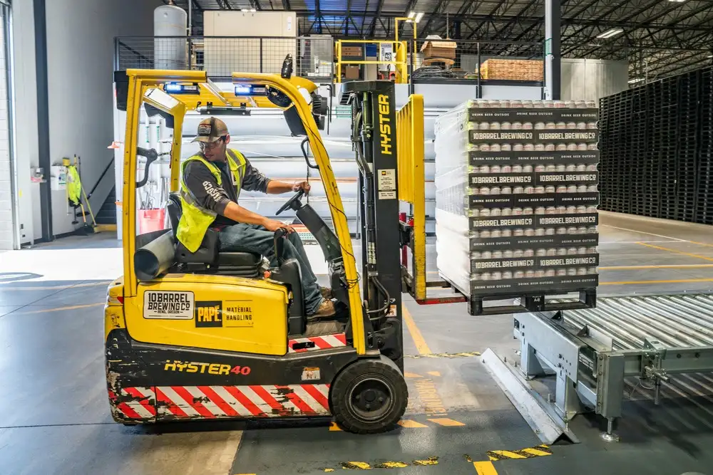 forklift storing pallettes in a warehouse